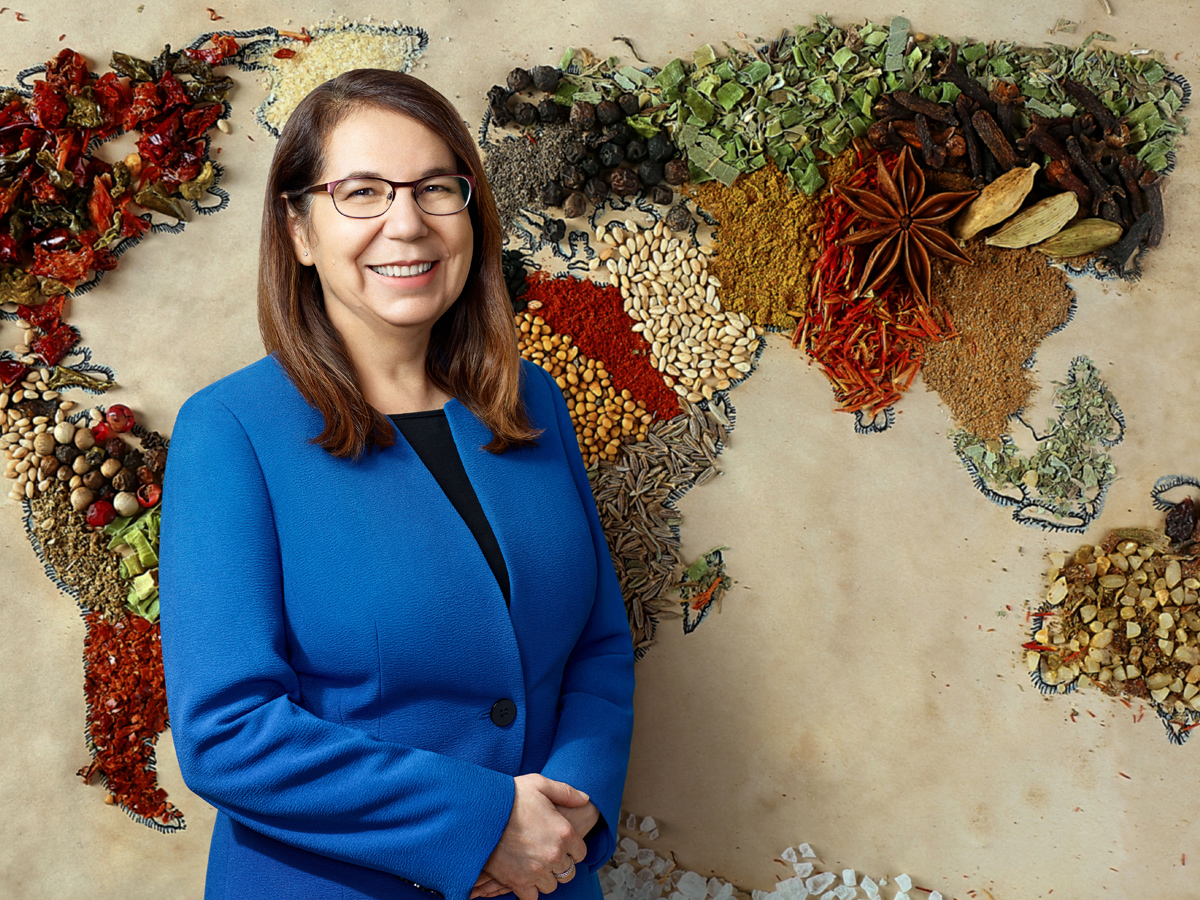 Cecilia Rocha (Nutrition), director of the Centre for Food Security, standing in front of a world map made out of dried spices