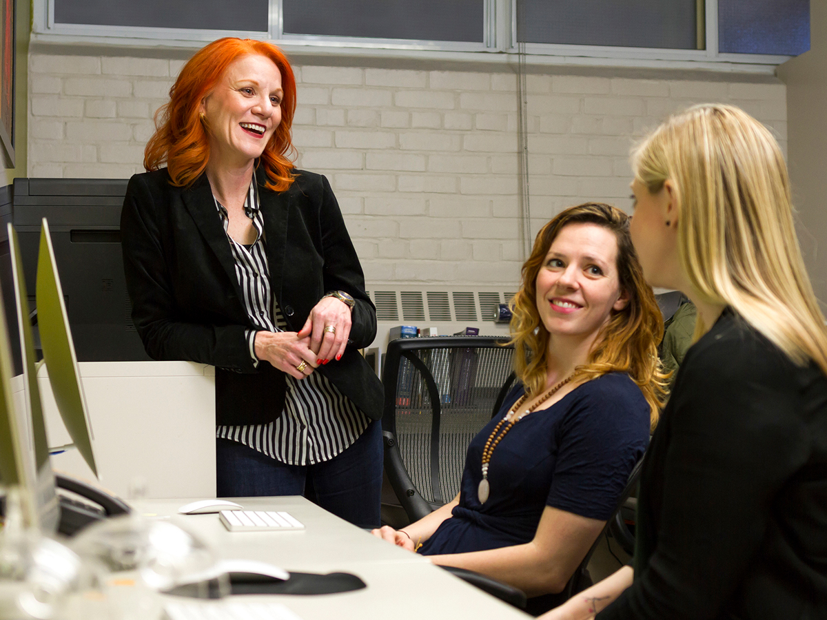 Professor Candice Monson talks with two other researchers in a lab