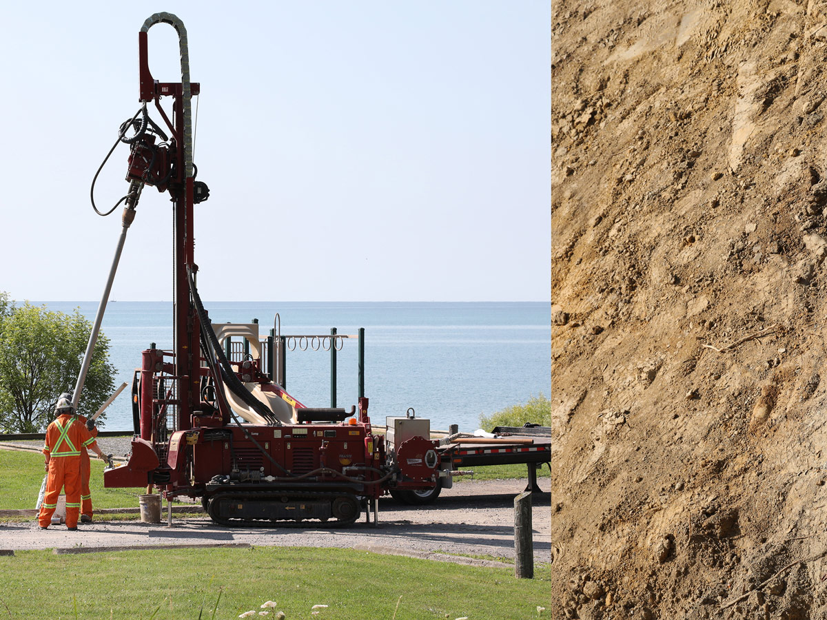 Two people in bright work overalls use heavy equipment to extract soil near a playground.