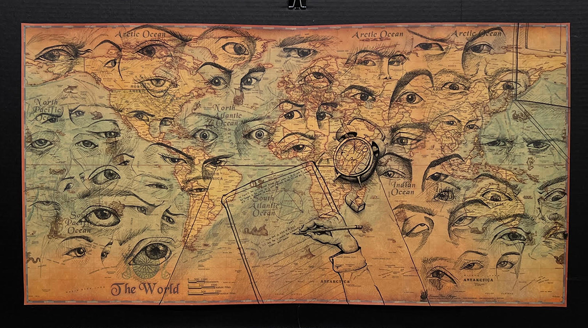 Photo of an artwork hung in an exhibit. The artwork consists of a world map covered with drawings of faces, eyes, an alarm clock and a math test.