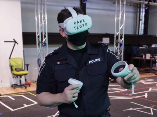 A police officer wears a Dark Slope branded VR headset and is using two handheld VR controllers.