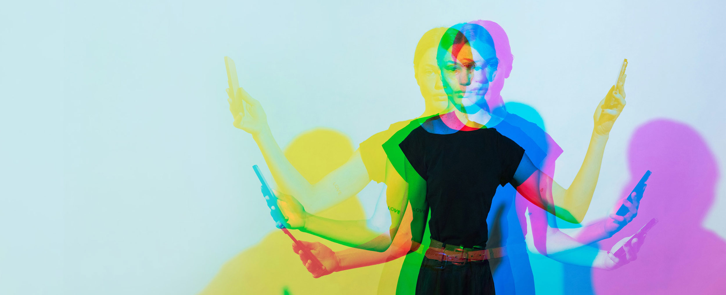 Multiple exposures of a young woman with a cell phone in each hand. Her shadow is depicted in different colours.