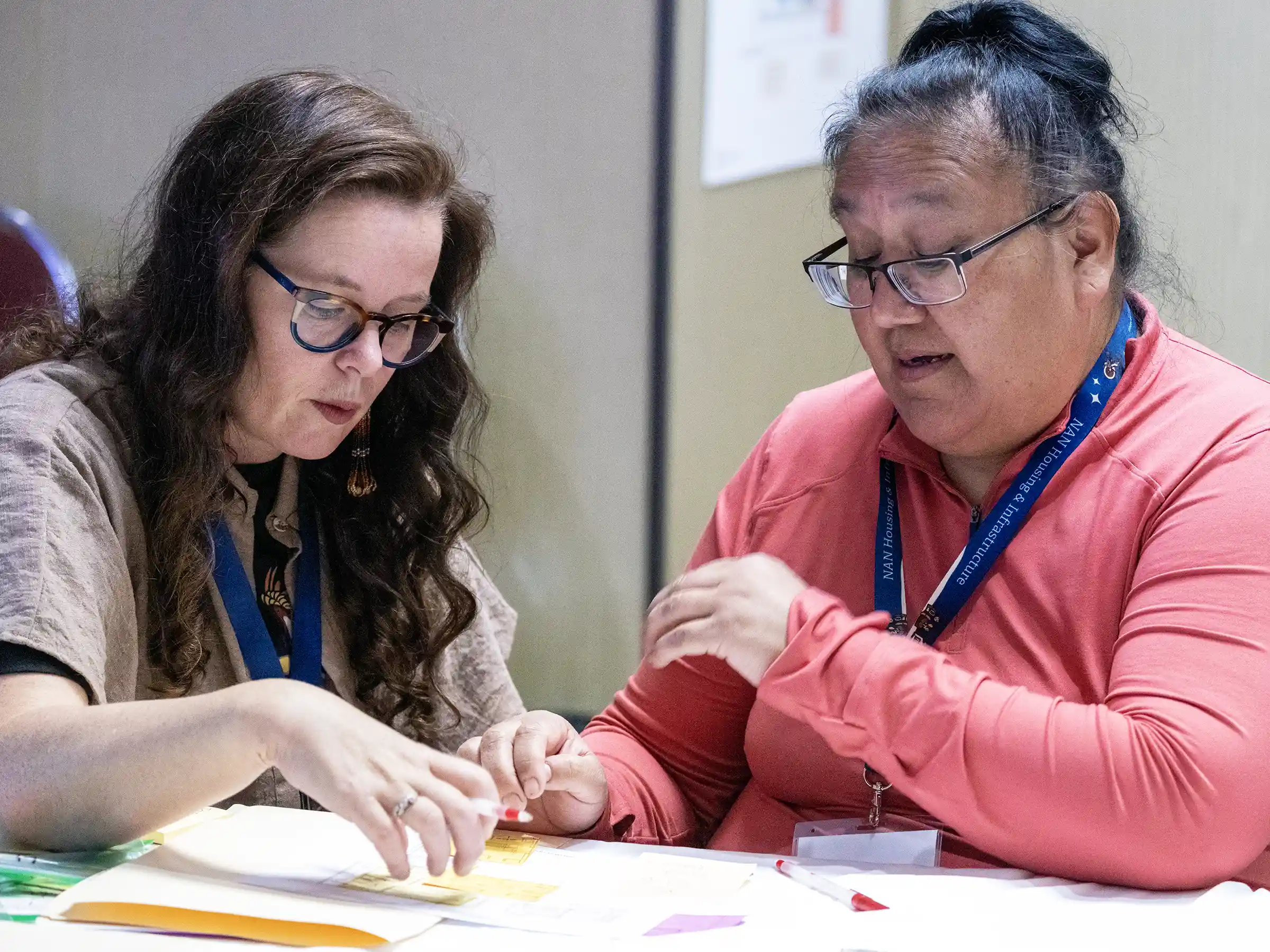  Two men guide each other through a flooded residential street.