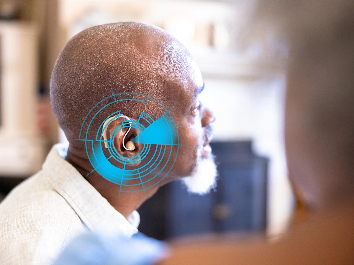 A man wearing a hearing aid with an illustration resembling a radar display superimposed over his ear.