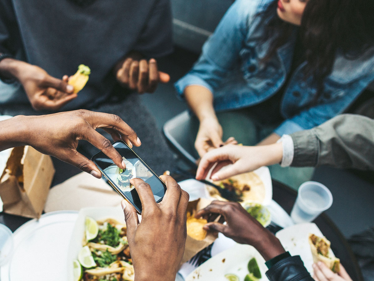 Young people sitting around a table and eating