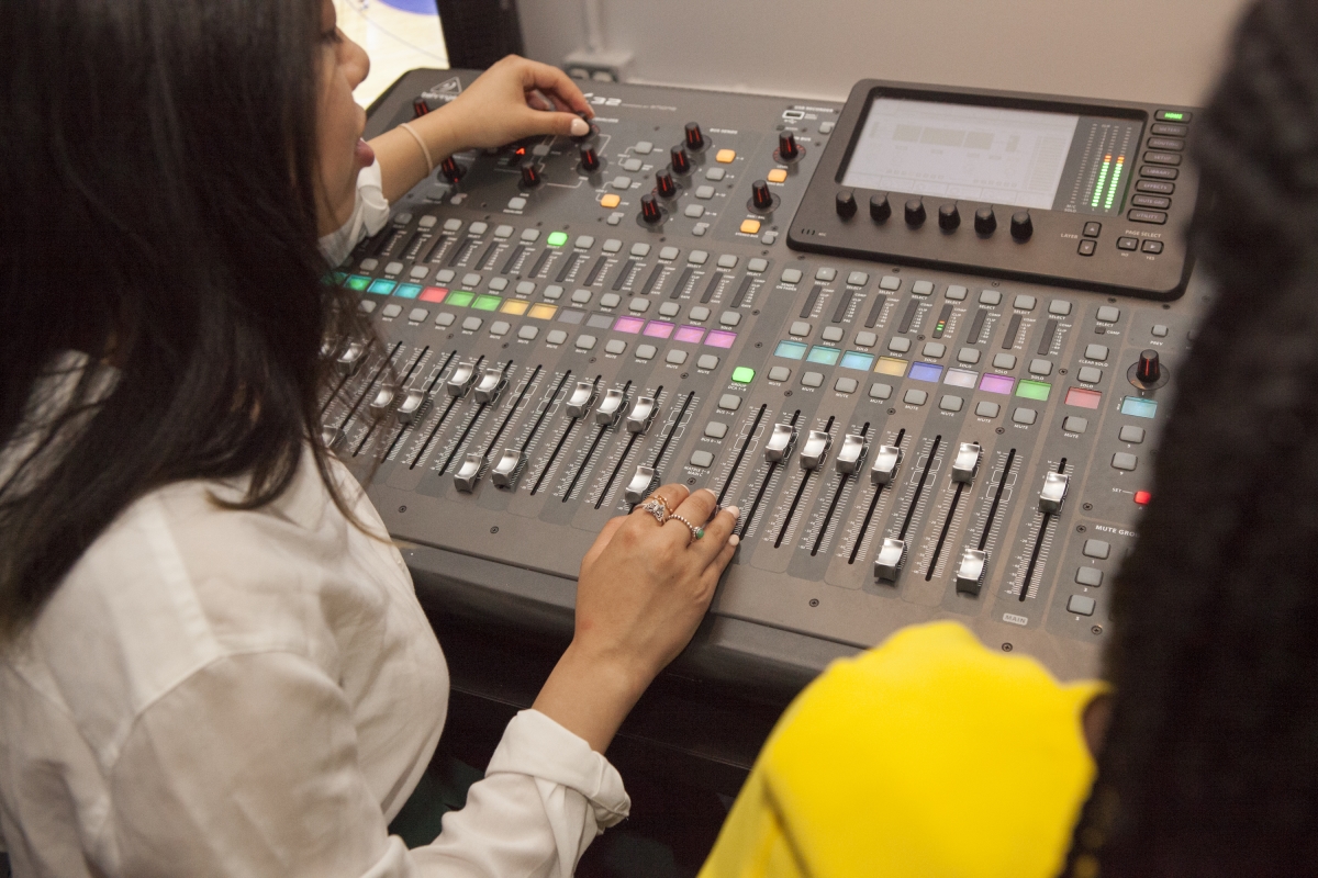 Pictured is a student adjusting audio on a mixer