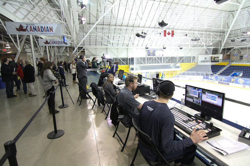 Students sit on the mezzanine at the Mattamy Athletic Centre with various production equipment preparing for a hockey game