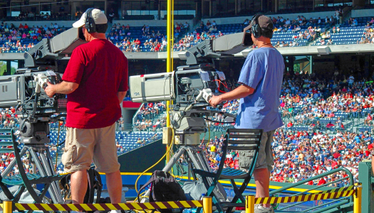 Two students using production cameras during a live match
