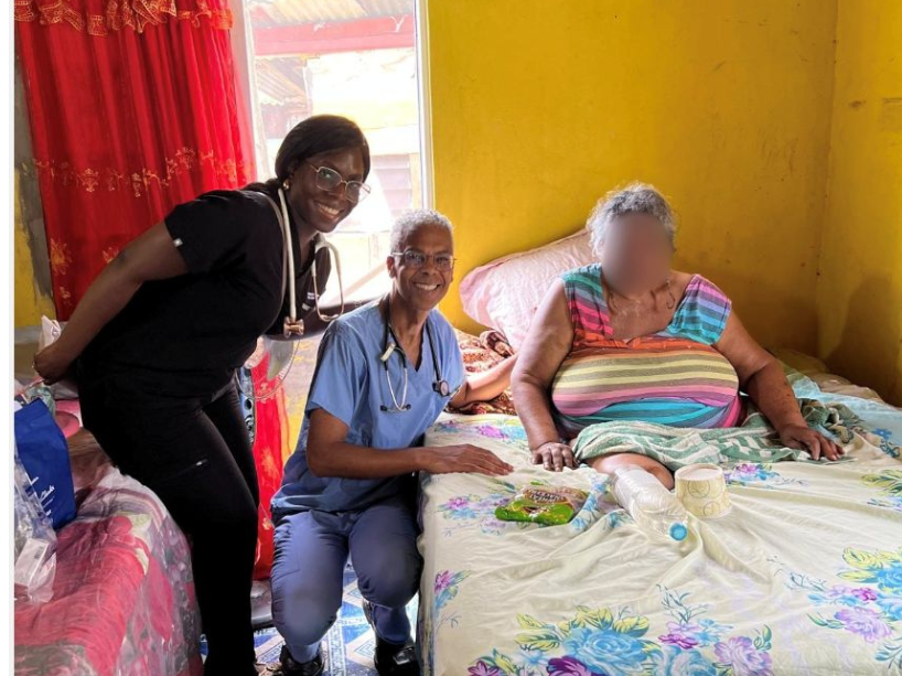 Two TMU doctors posing with a patient in their home in Jamaica