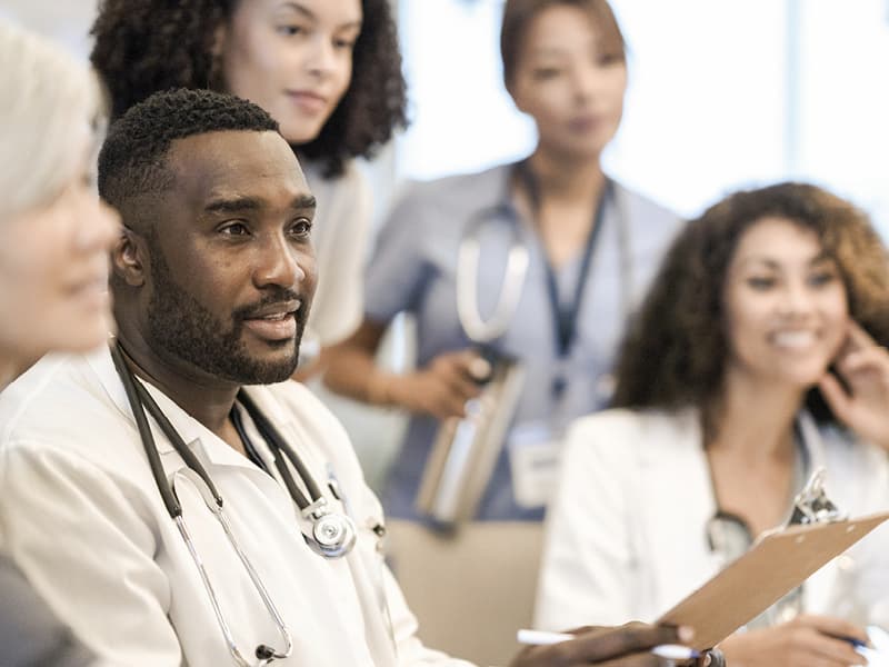 A diverse group of doctors and nurses engaged in a conversation
