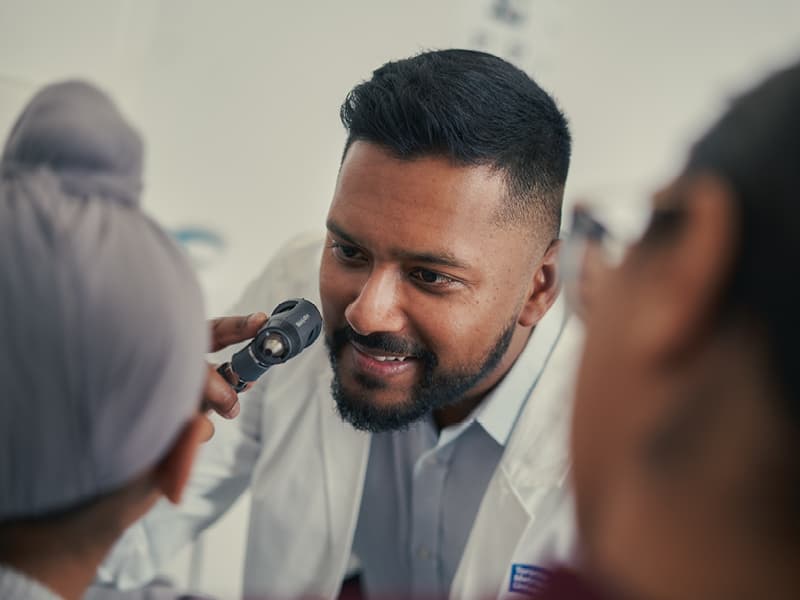 A doctor examining a child with a smile on his face