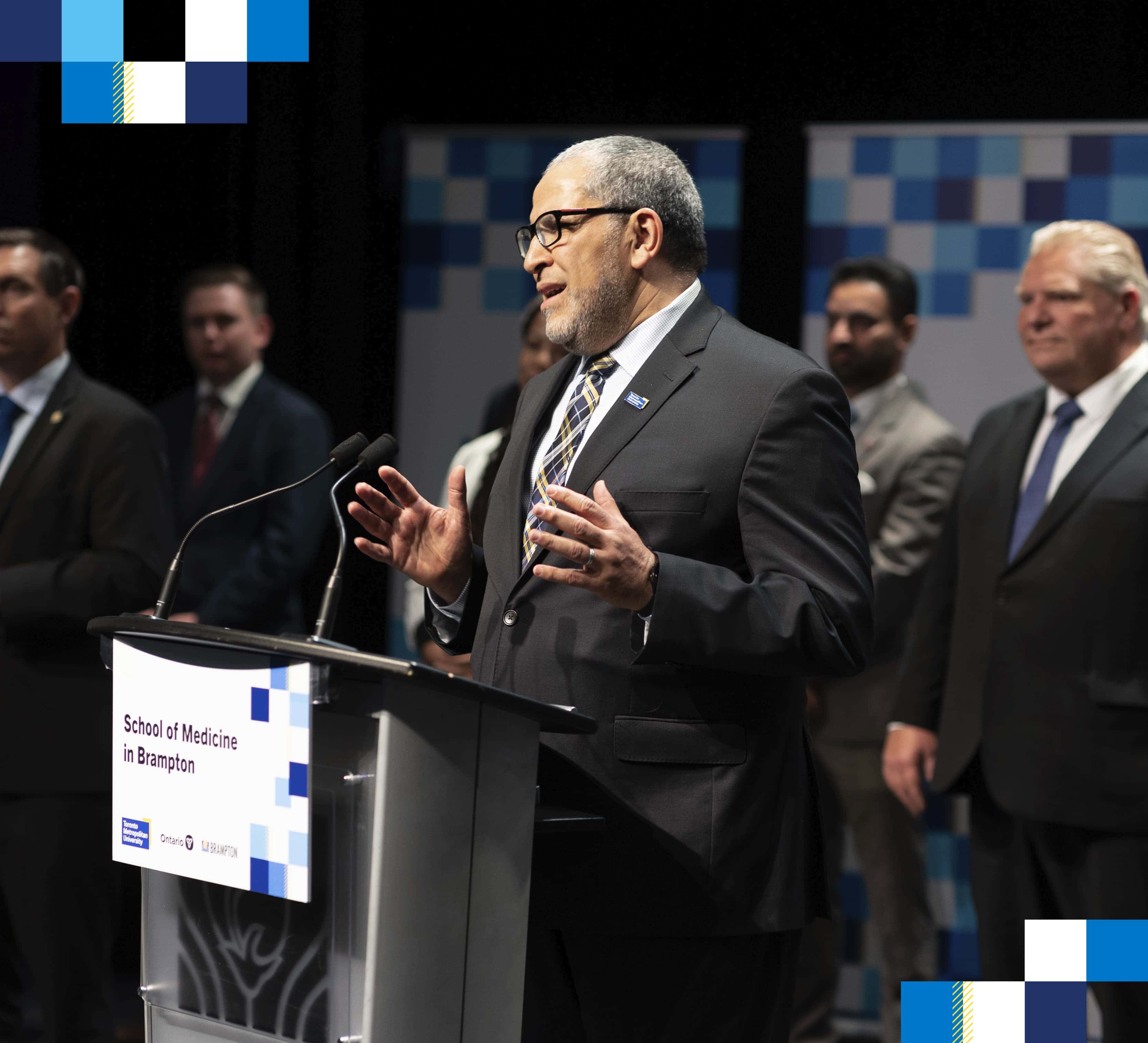 TMU President Mohamed Lachemi standing at a podium with Ontario Premier Doug Ford to his right.
