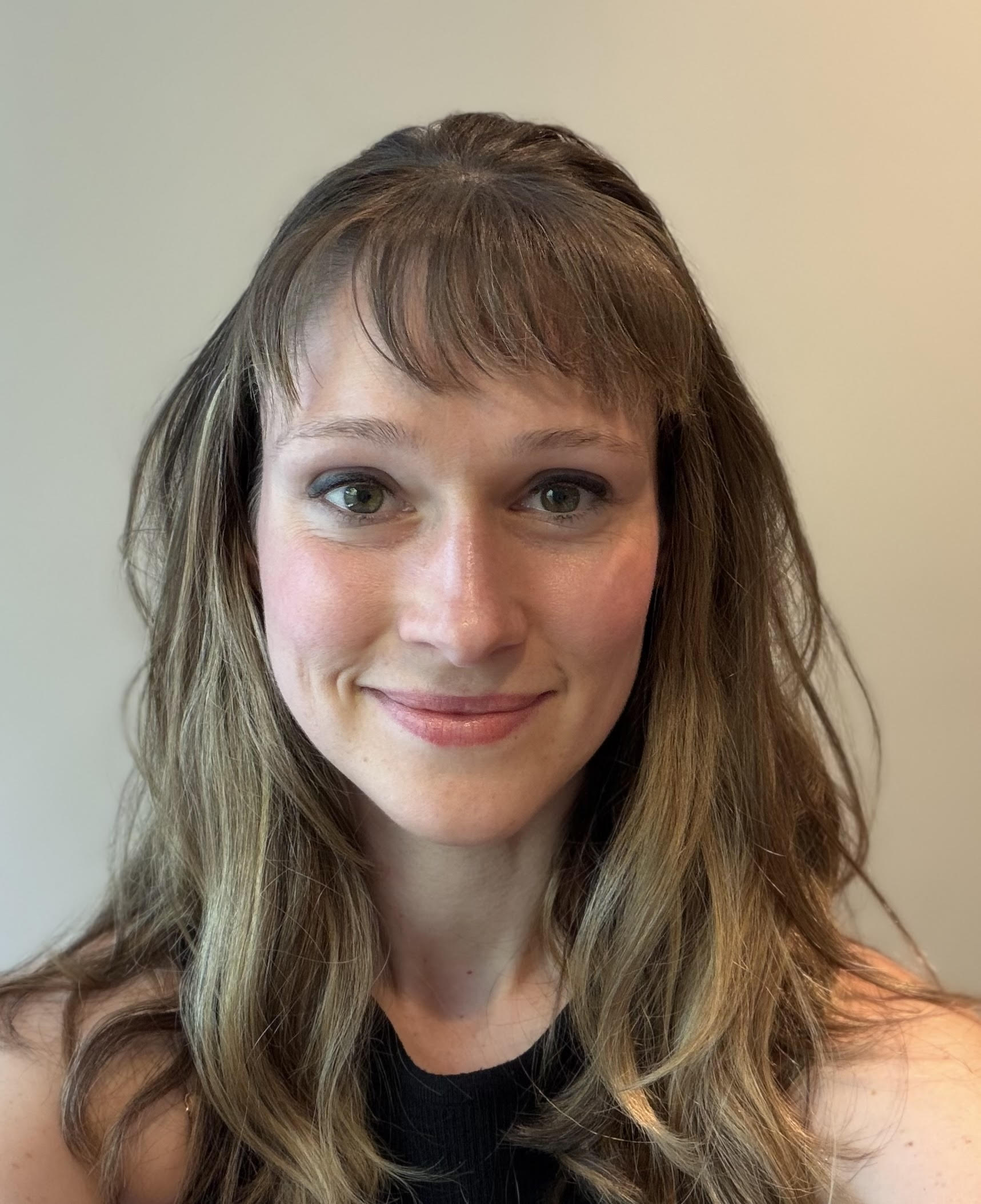 Dr. Rachel Johnson smiles in front of  a wall.