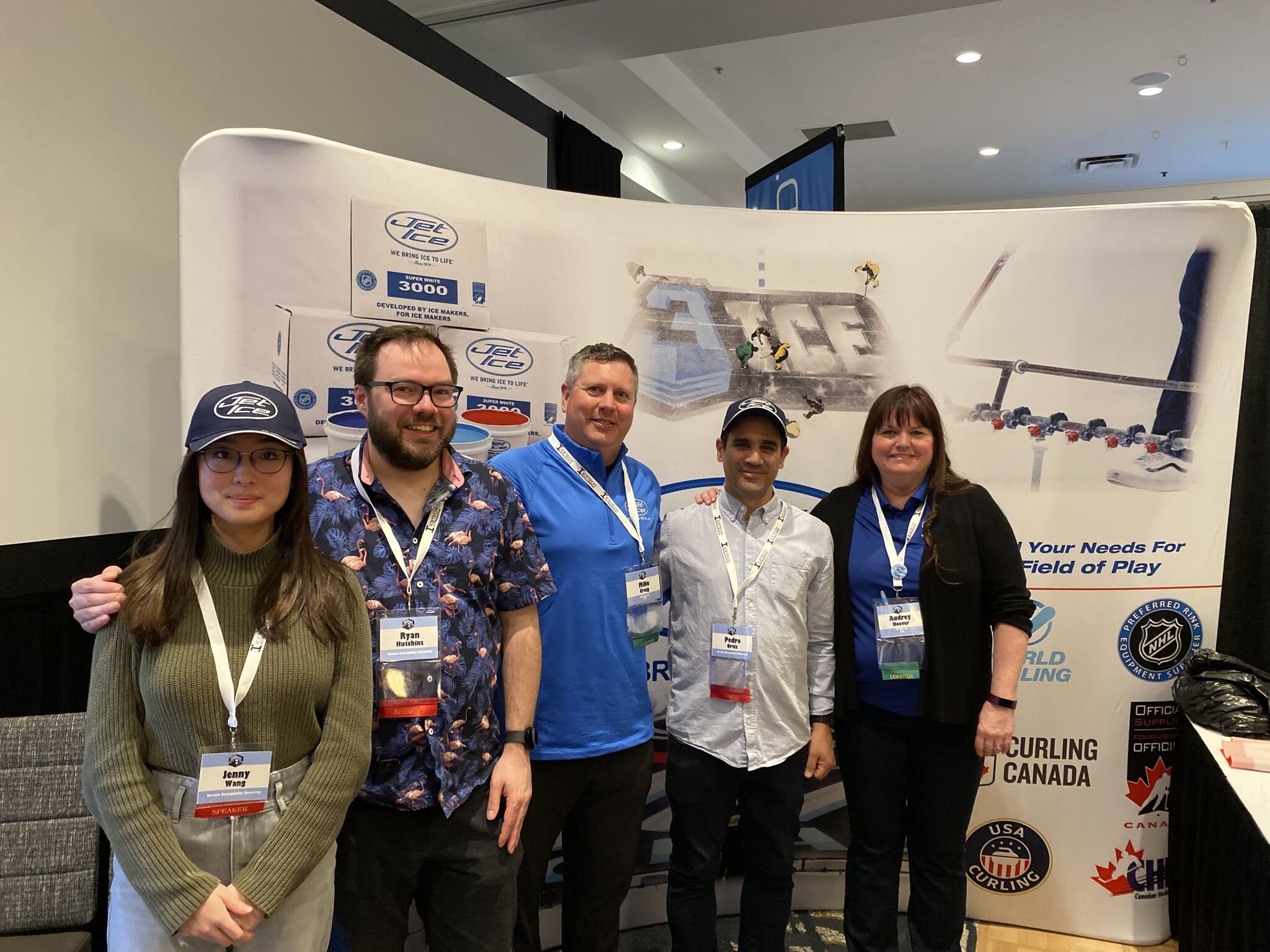 TMU research group and Jet Ice in front of Jet Ice backdrop at a conference