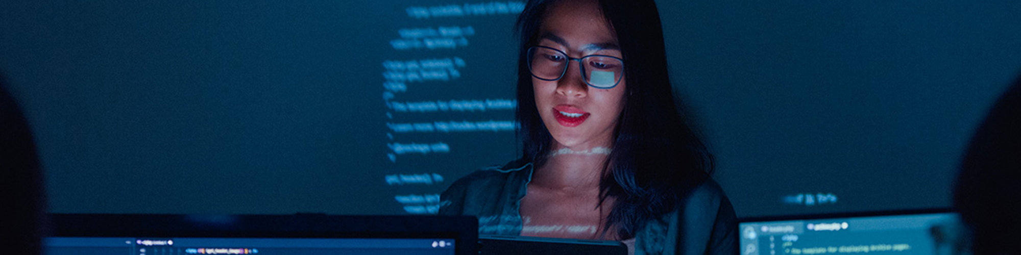 Student looking at a screen with code projected in the background