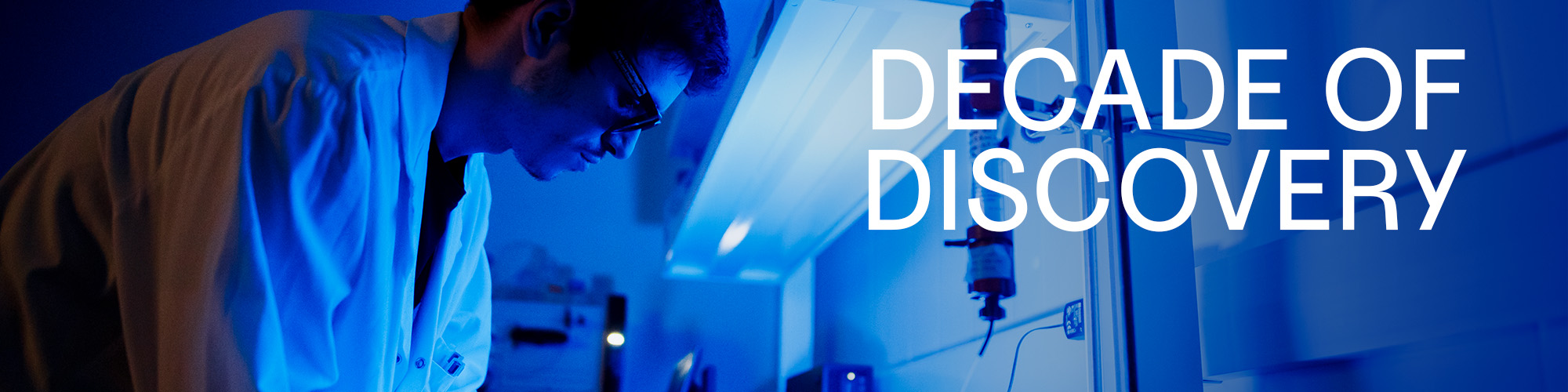 Scientist with blue lighting with the words Decade of Discovery
