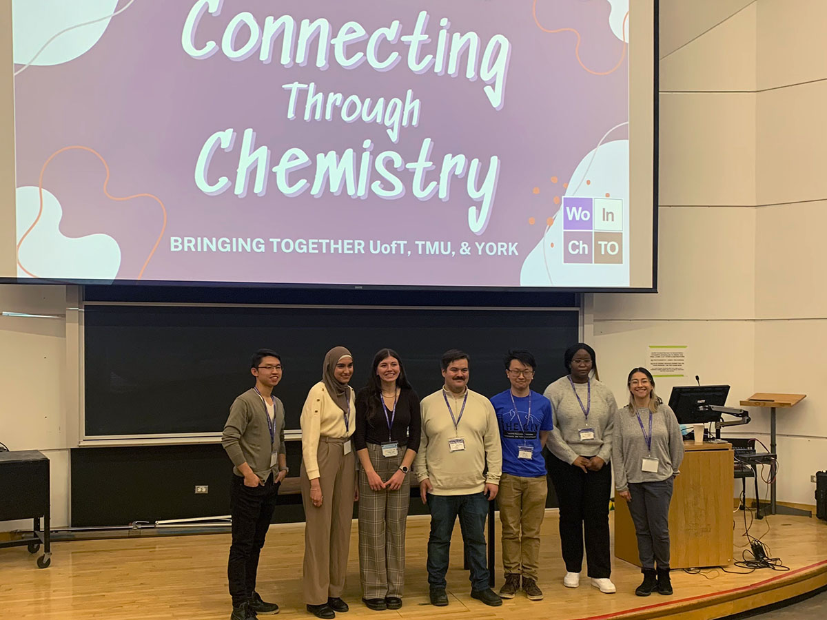 Group of graduate students standing on stage at Connecting through Chemistry symposium