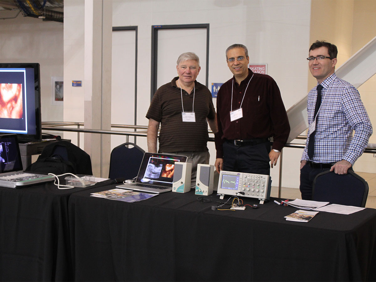 Professor Jahan Tavakkoli and former colleagues presenting ultrasound research at a university event
