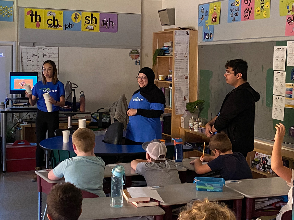 SciXchange volunteers Meghan Koo, Zayneb Al-Hantoshi and Ali Hashmi teaching elementary students at Maynooth Public School