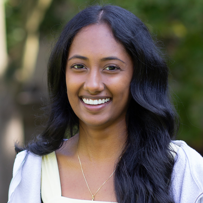 headshot of Althea Pioquinot, with long black hair, smiling, wearing navy shirt