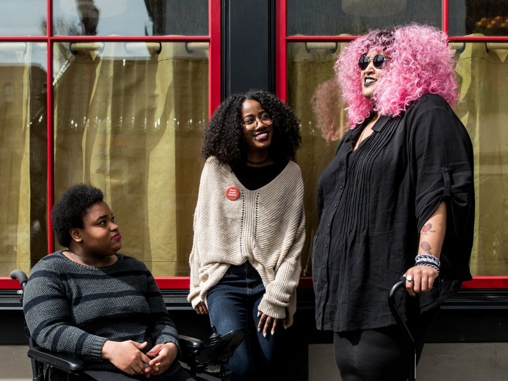 Two women and one woman in a wheelchair talking