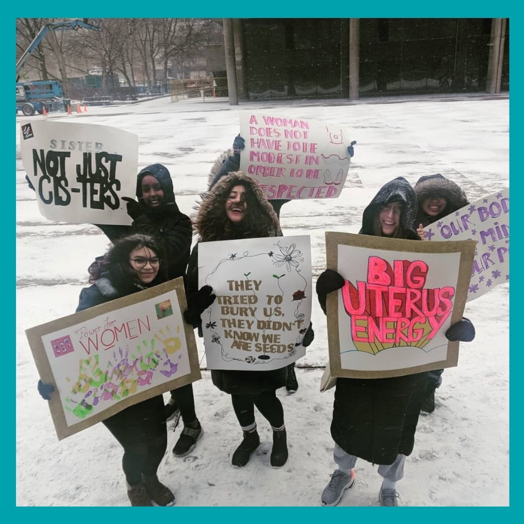 Four student, from the consent action team, holding signs.