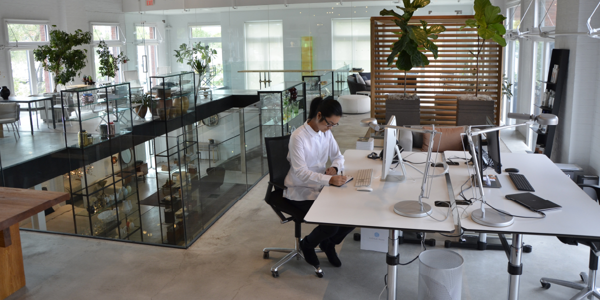Person working in a open concept office front of a computer screen