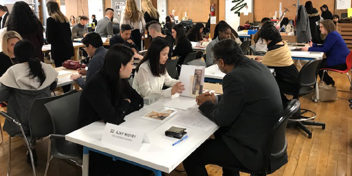 Group of people sitting a busy space around different desks