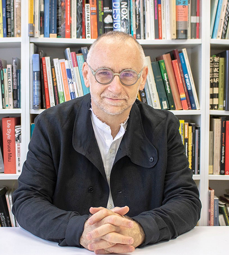 Man smiling with his hands folded.