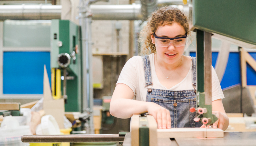 Student wearing security glasses and using a sewing machine