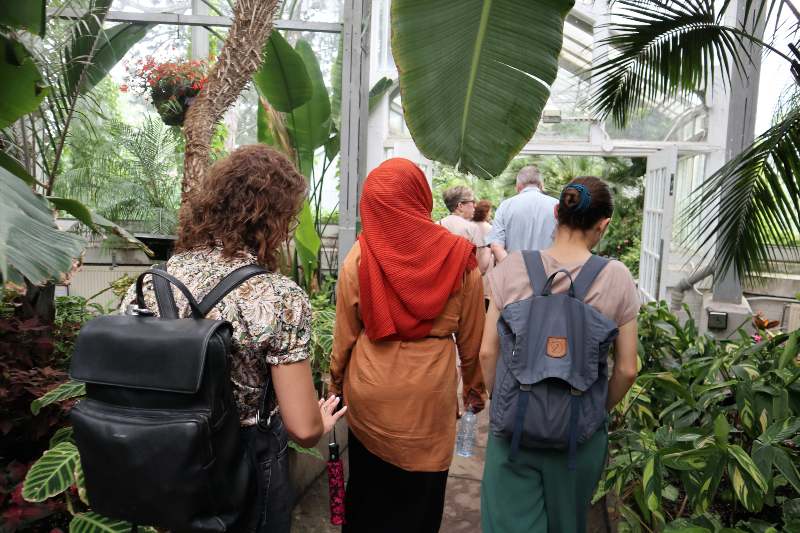 Students with backpacks walk through Allan Gardens.