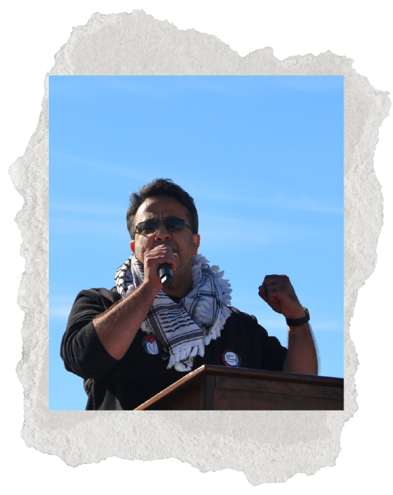 Photo of man with keffiyeh around neck, speaking - Ala' Qadi