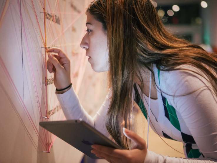 Woman interacting with Innovate TO 150 display, while holding a tablet.