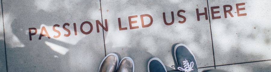  Lettering on a sidewalk reading 'passion led us here'