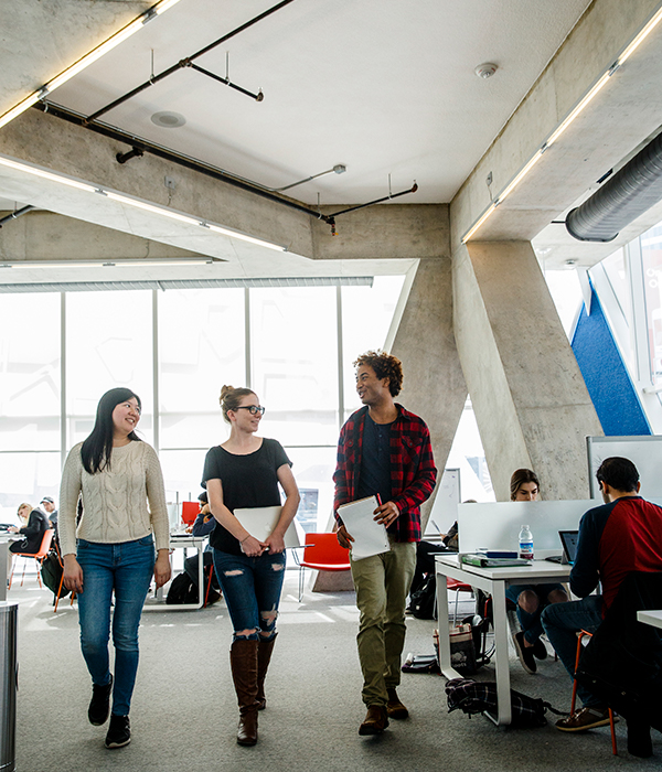 Three students walking in the Student Learning Centre (SLC)