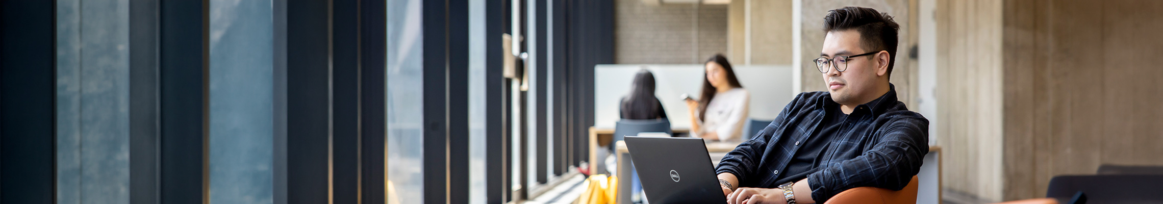 Student on laptop in TMU building