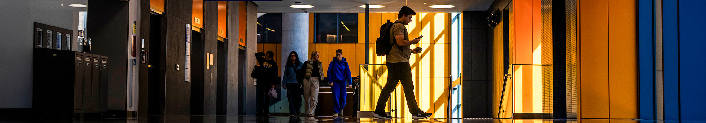 Interior shot of campus with students walking in a hallway
