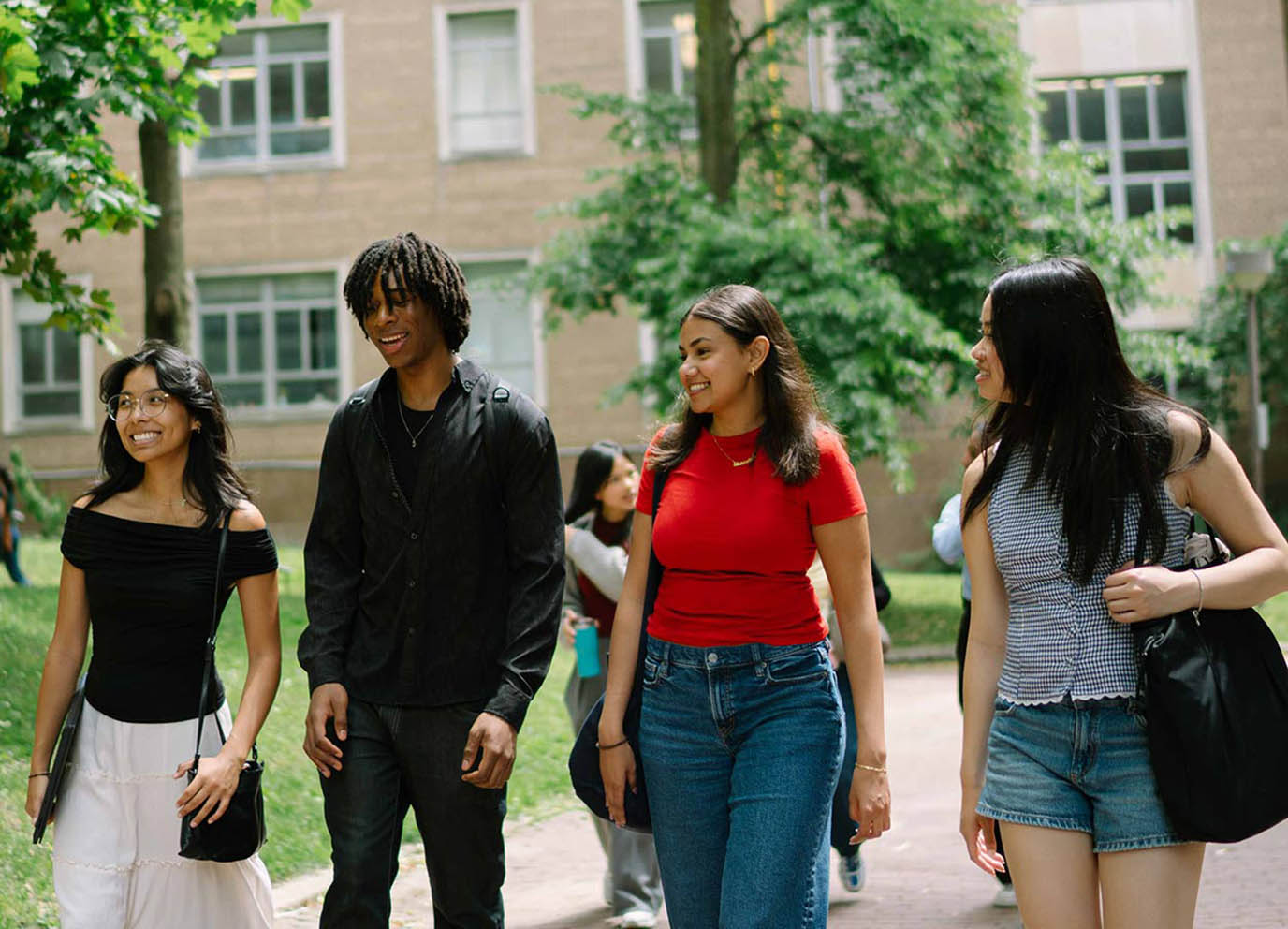 Four students walk outside on TMU campus