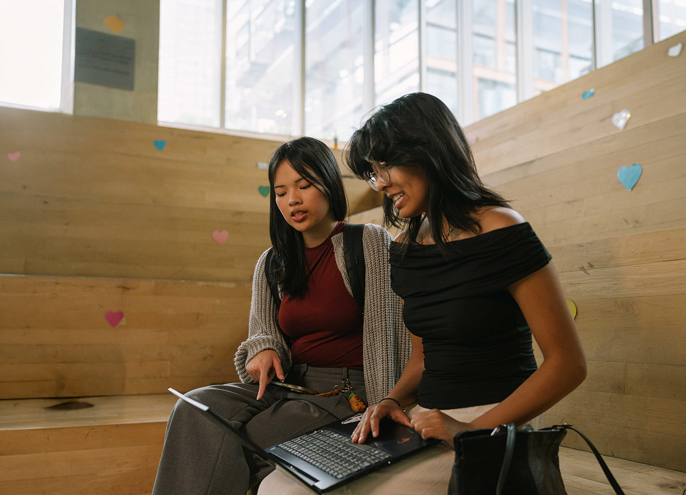Two students sitting in SLC checking a laptop for updates