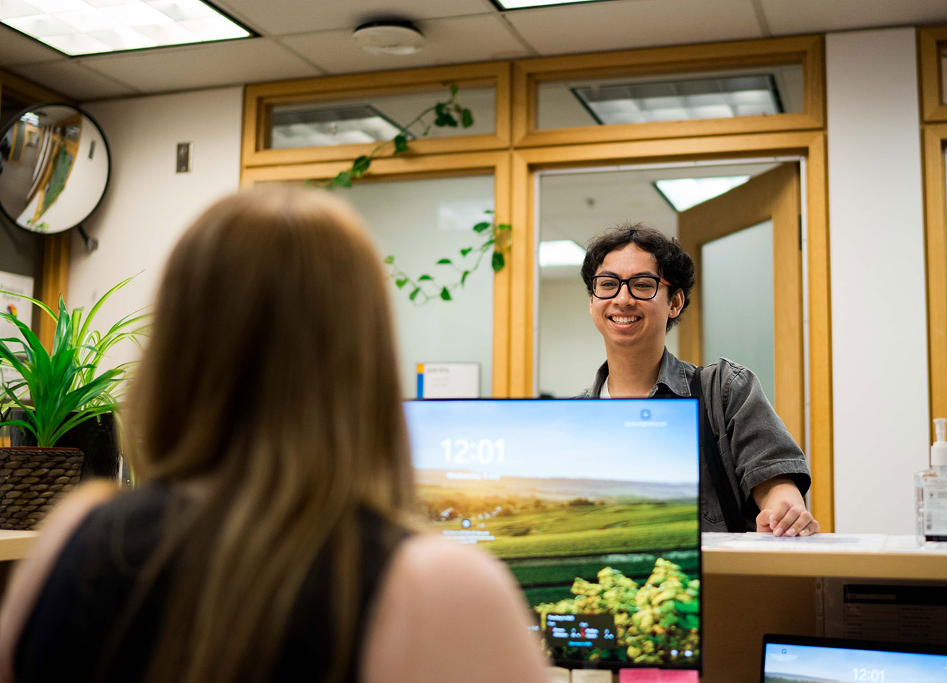 Student stands at help desk smiling