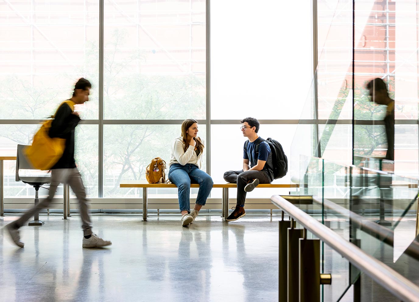 Students sit on a bench at TMU