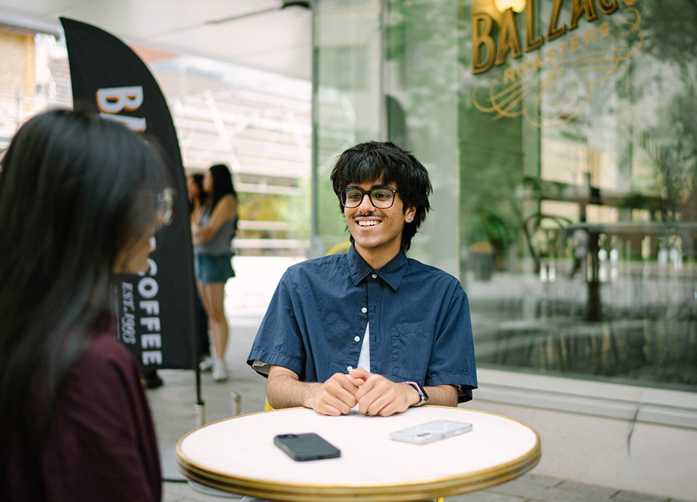 A pair of students laugh at a table together on Gould Street