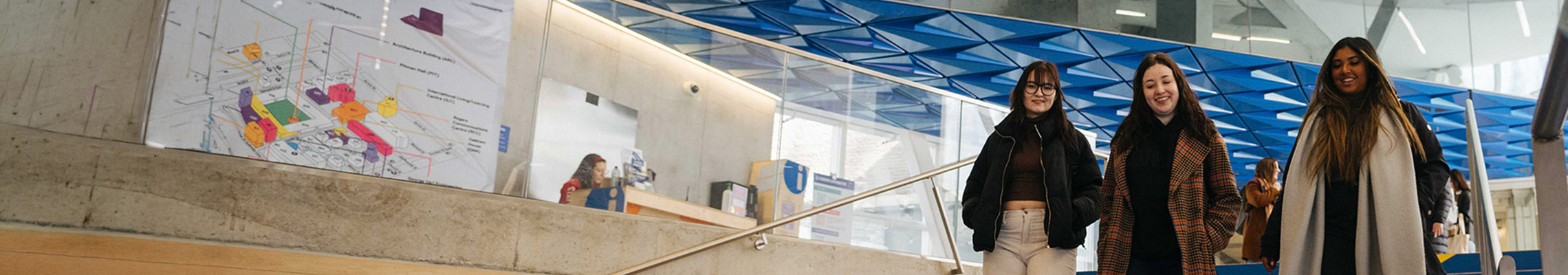 Three students walking down steps in Student Learning Centre