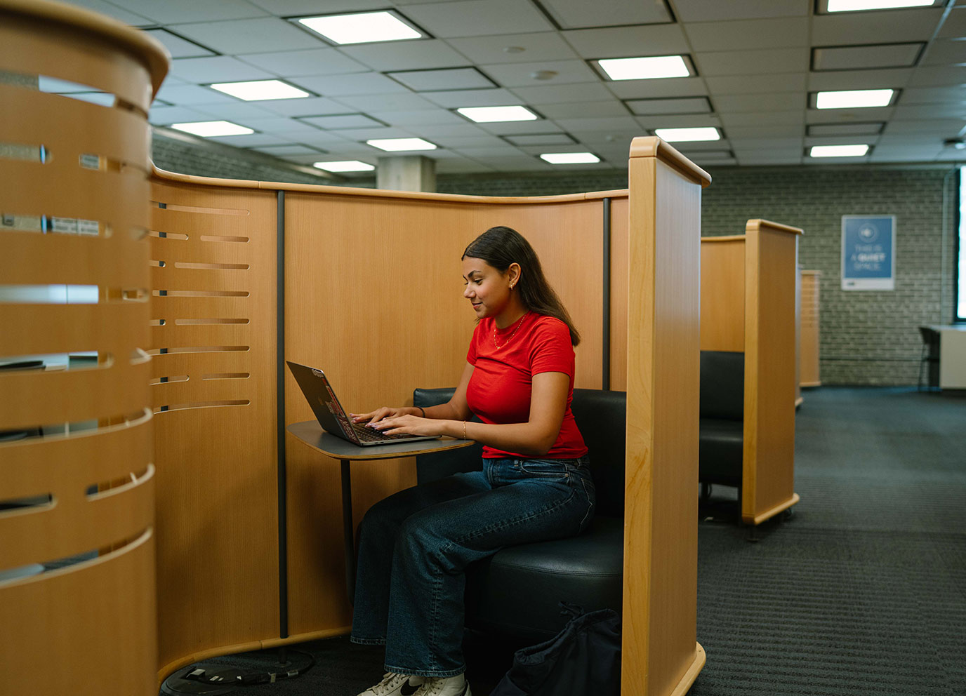 Career Boost student on laptop in a workspace on TMU campus