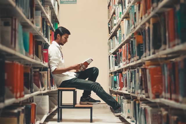student sitting and reading in library