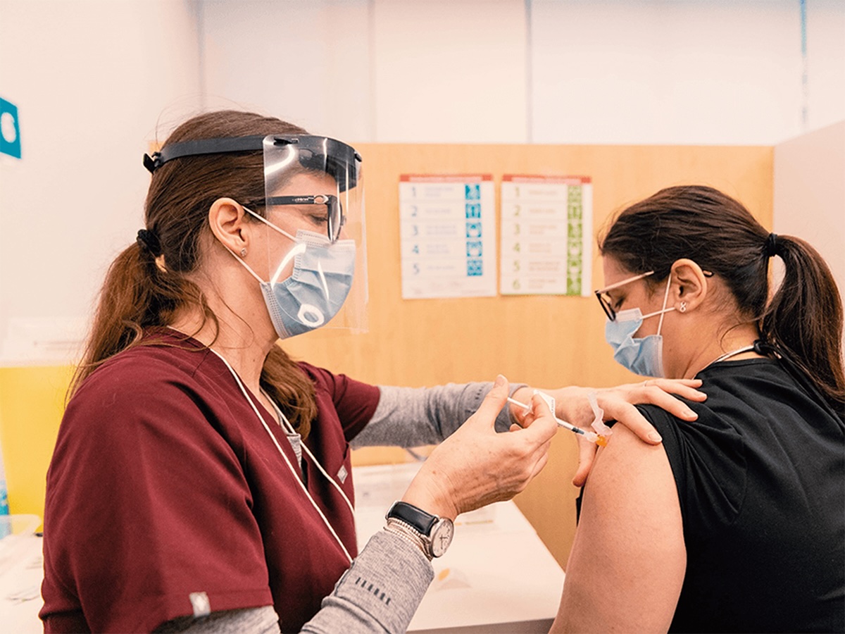 A medical professional administers a flu shot into a patient.