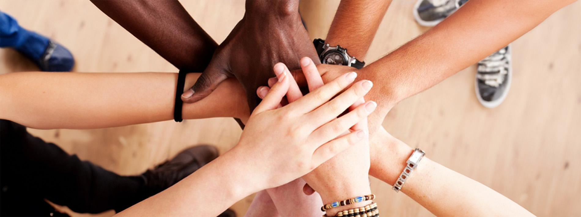 A group of individual's hands piled on top of one another as a symbol of unity and team effort.