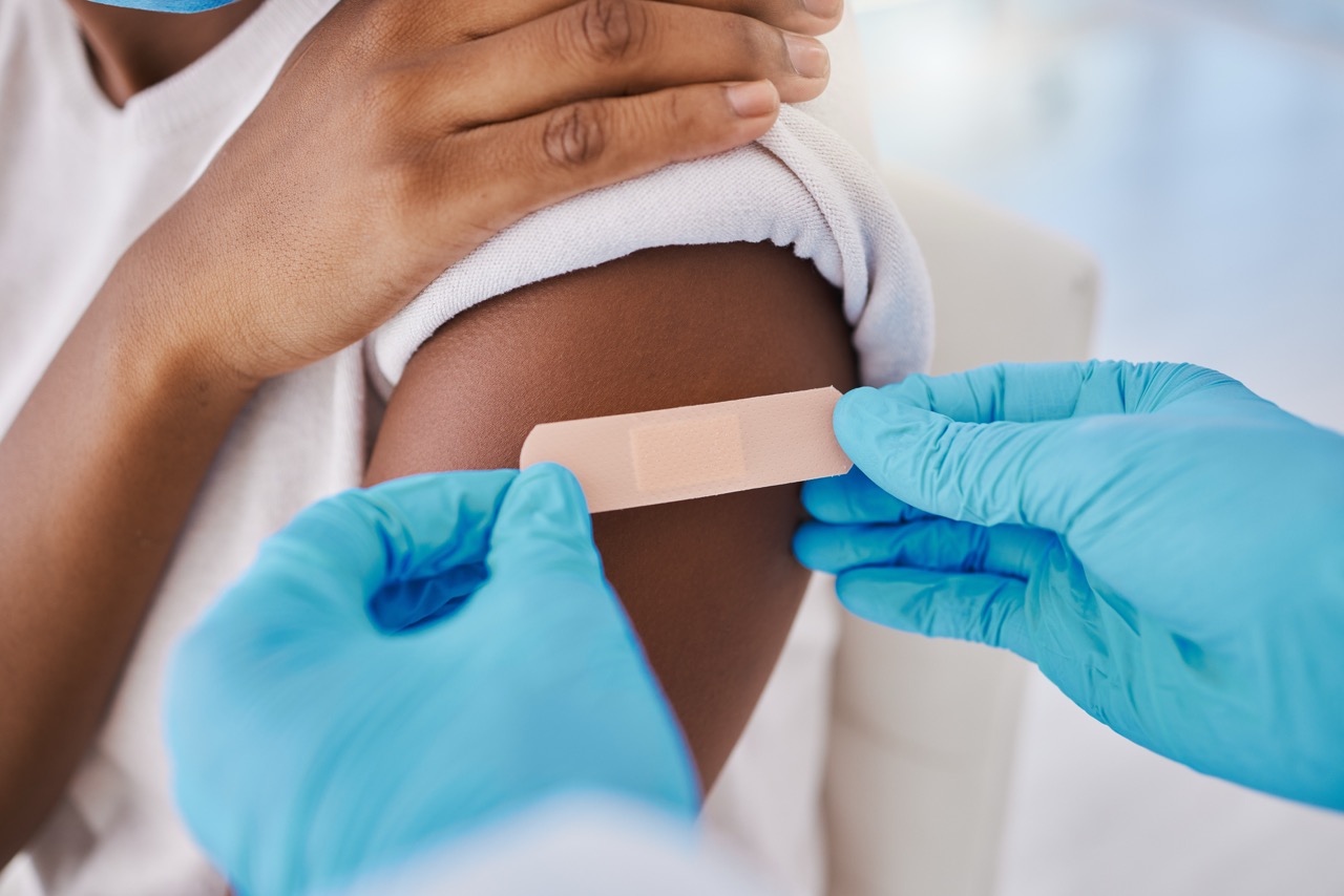 Plaster bandage on arm for covid vaccine, injection and cure given to patient by a doctor in a hospital. Closeup of flu jab, antiviral shot and health treatment to boost immunity and prevent illness