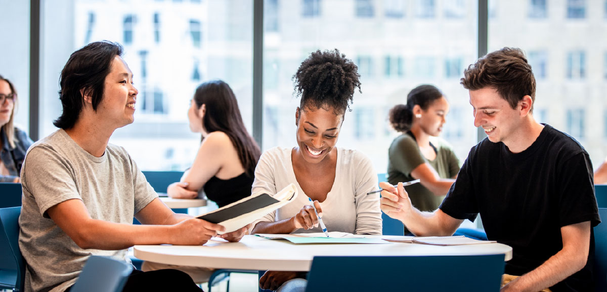 A group of students smiling and studying.