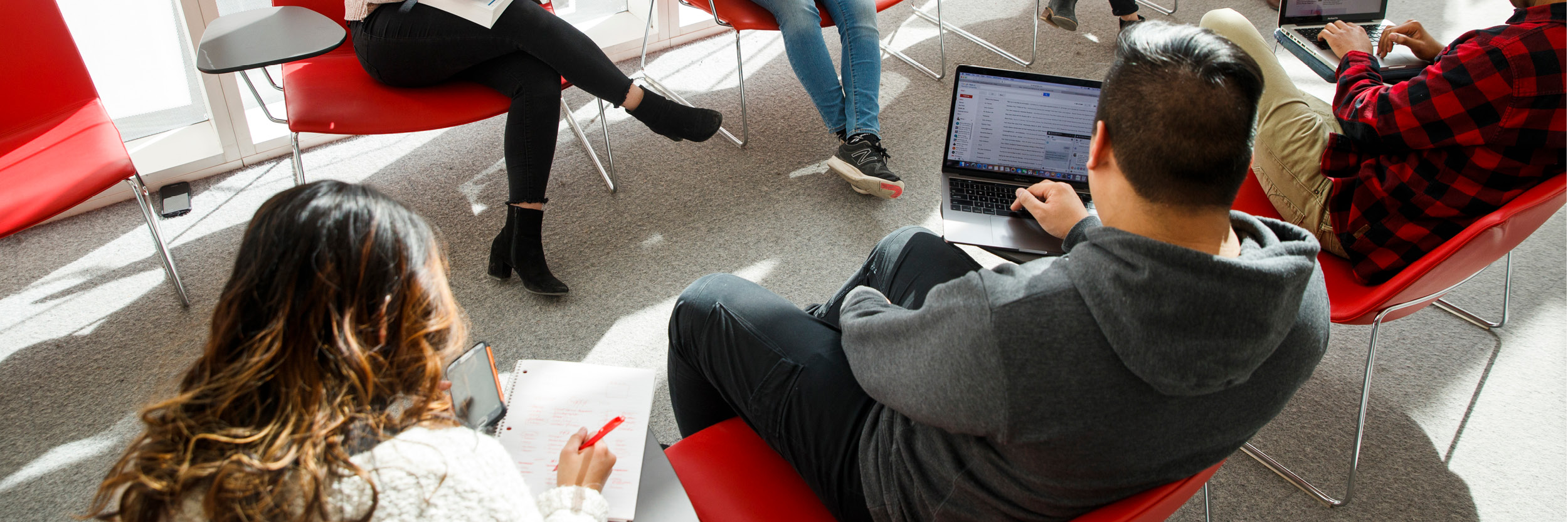 Group of students studying on their laptops in the SLC.
